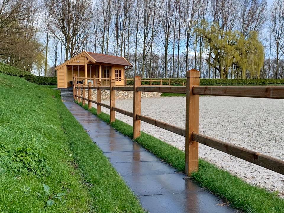 weiland met omheining en een sloot. De omheining zit om de paardenbak heen.